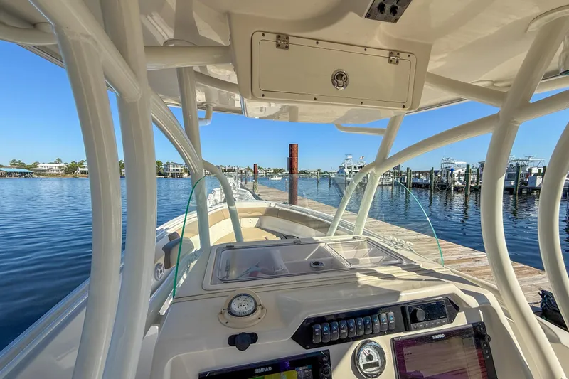 Slide: The Image of 2017 Sailfish 290 CC boat dashboard view at marina with clear blue sky. - 25
