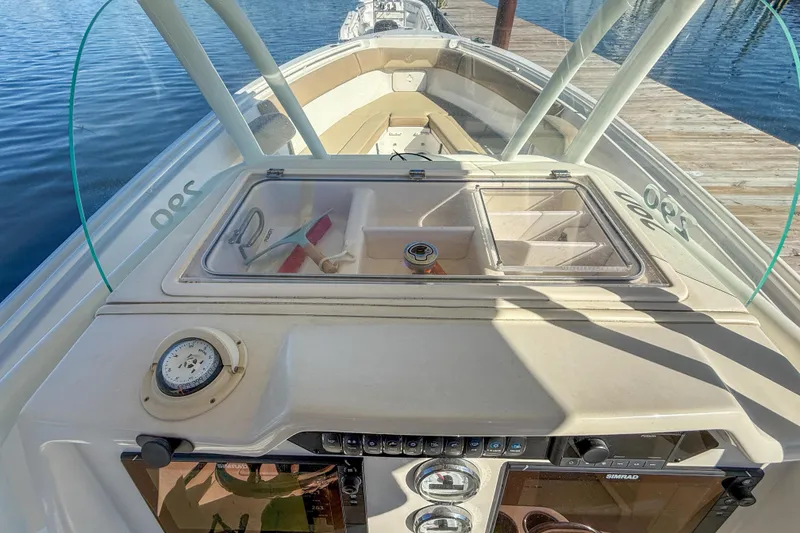 Slide: The Image of 2017 Sailfish 290 CC boat dashboard with compass and storage compartments. - 26
