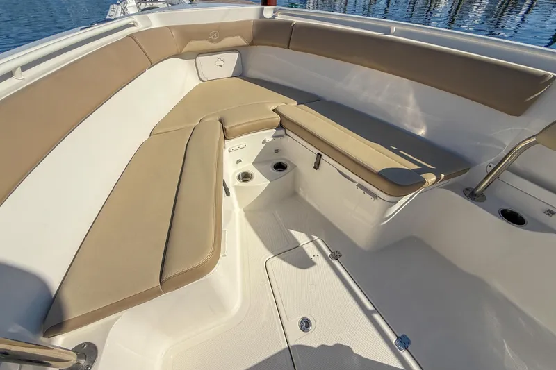 Slide: The Image of 2017 Sailfish 290 CC boat interior with tan cushioned seating and white deck. - 28