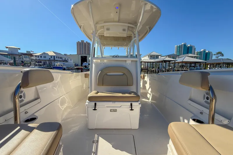 Slide: The Image of 2017 Sailfish 290 CC boat interior with seating and Yeti cooler, docked at marina. - 29