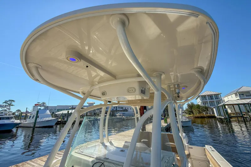 Slide: The Image of 2017 Sailfish 290 CC boat with T-top, docked at marina under clear blue sky. - 30