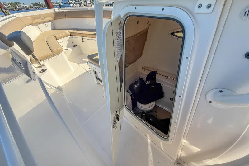 Slide: The Image of 2017 Sailfish 290 CC boat interior with open storage compartment and seating area. - 32