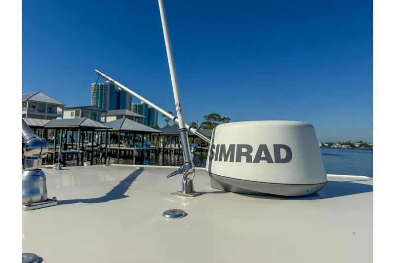 Slide: The Image of 2017 Sailfish 290 CC boat with Simrad radar, docked near waterfront buildings. - 34