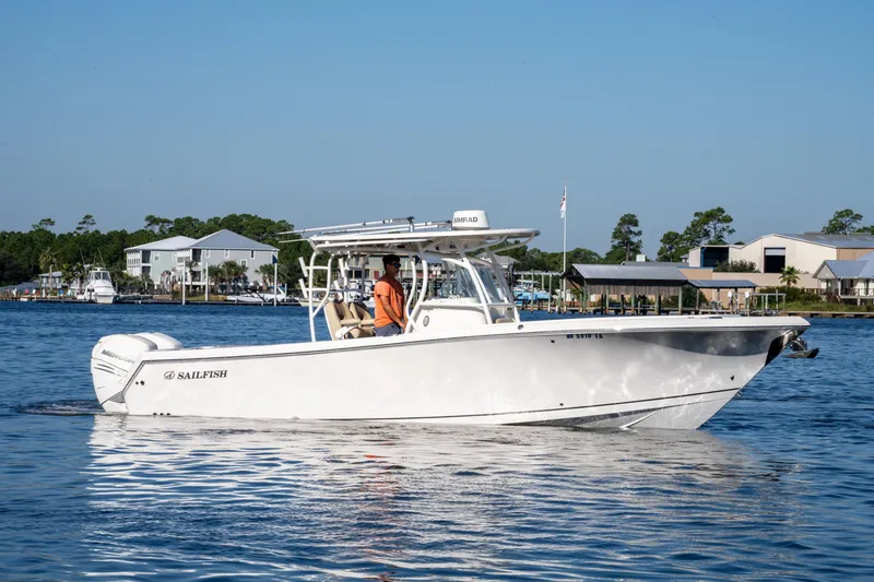 Slide: The Image of 2017 Sailfish 290 CC boat cruising on a calm waterway near residential docks. - 6