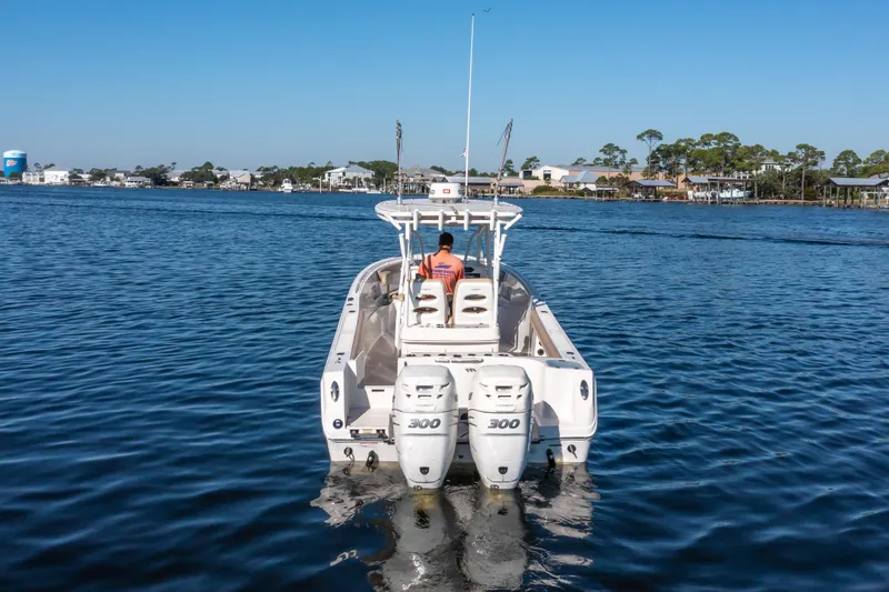 Slide: The Image of 2017 Sailfish 290 CC boat cruising on a calm lake with a clear blue sky. - 8