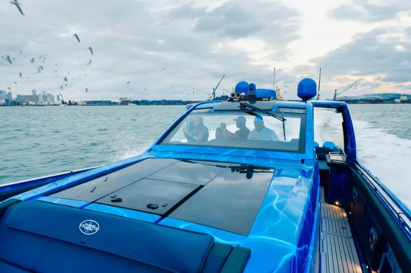 Slide: The Image of 2024 Cigarette 59 Tirranna speedboat cruising on open water with city skyline backdrop. - 17