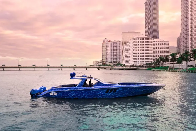 Slide: The Image of 2024 Cigarette 59 Tirranna boat on water with city skyline backdrop at sunset. - 21