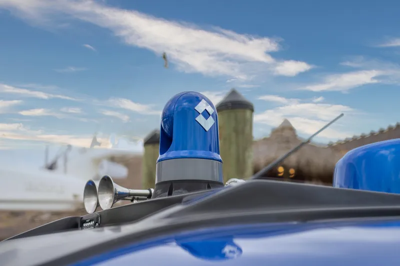 Slide: The Image of Manufacturer Provided Image: Close-up of 2024 Cigarette 59 Tirranna's blue light and horn against a scenic background. - 8