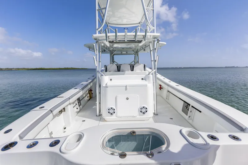 Slide: The Image of 2018 Yellowfin 42 Offshore boat on calm water, showcasing spacious deck and seating. - 18