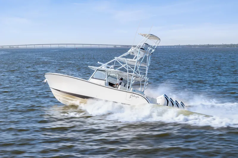 Slide: The Image of 2018 Yellowfin 42 Offshore boat cruising on open water, bridge in background. - 2