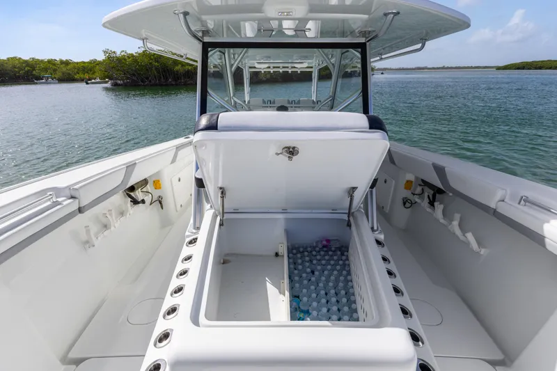 Slide: The Image of 2018 Yellowfin 42 Offshore boat with open storage compartment, filled with water bottles, on a calm waterway. - 29