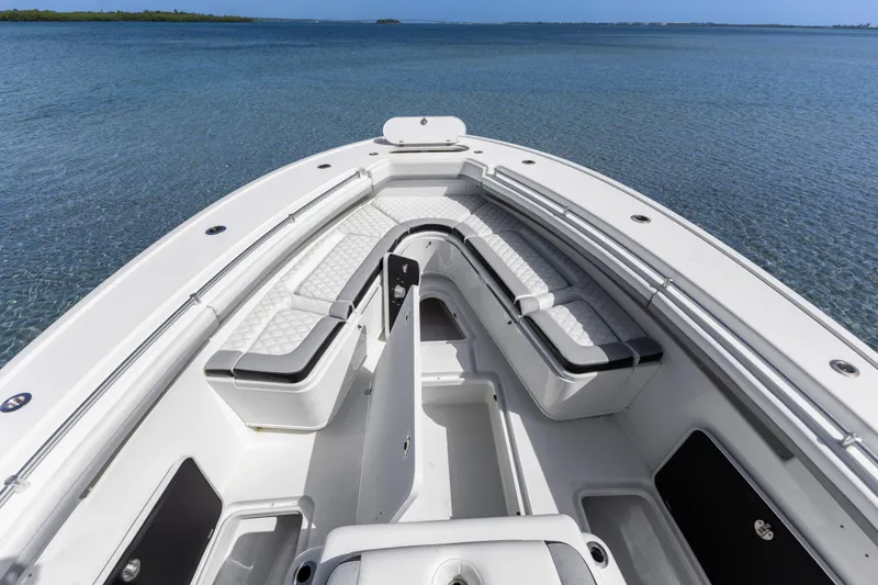 Slide: The Image of 2018 Yellowfin 42 Offshore boat interior with cushioned seating, overlooking calm blue waters. - 34