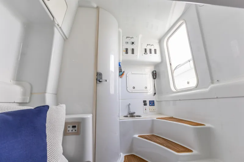 Slide: The Image of 2018 Yellowfin 42 Offshore cabin interior with control panels and wooden steps. - 44