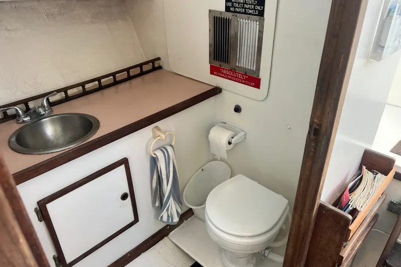 Slide: The Image of 1995 Young Brothers 38 Fly Bridge boat bathroom with sink, toilet, and storage. - 13