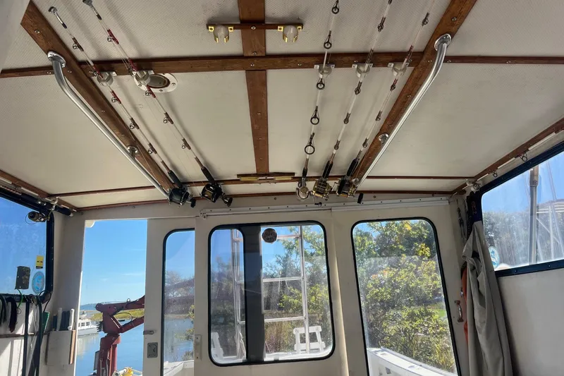 Slide: The Image of Interior view of 1995 Young Brothers 38 Fly Bridge with fishing rods on ceiling. - 17