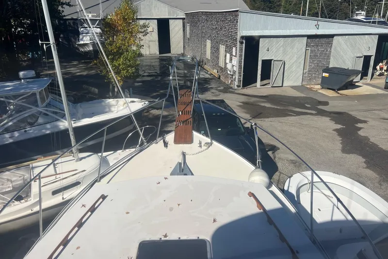 Slide: The Image of 1995 Young Brothers 38 Fly Bridge boat docked at a marina with nearby buildings. - 5