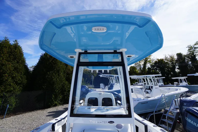 Slide: The Image of 2026 Tidewater 220 LXF boat with blue T-top, displayed outdoors. - 17
