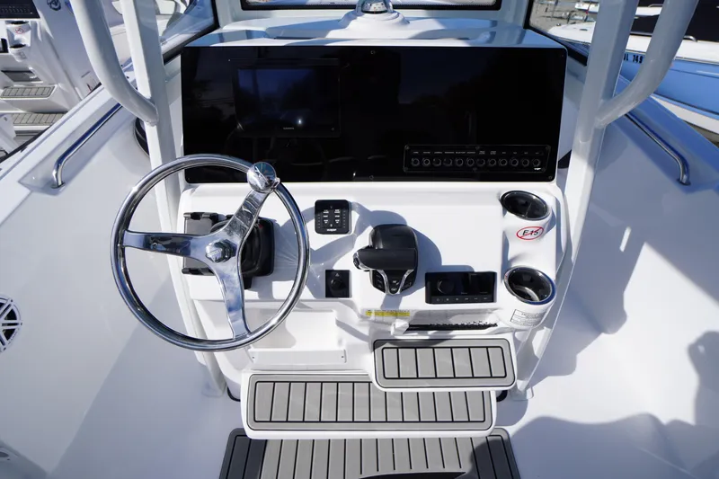 Slide: The Image of 2026 Tidewater 220 LXF boat console with steering wheel and controls. - 21