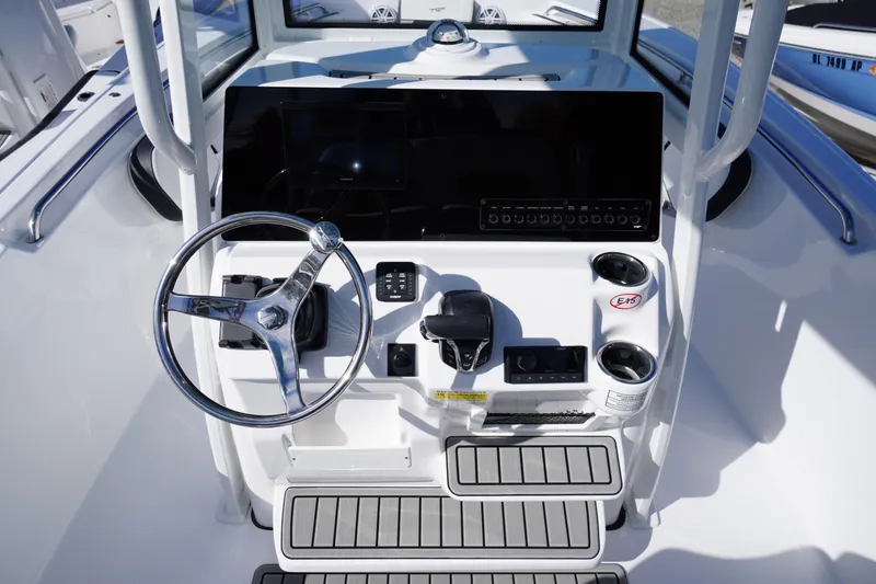 Slide: The Image of Steering console of 2026 Tidewater 220 LXF boat with modern controls and cup holders. - 24
