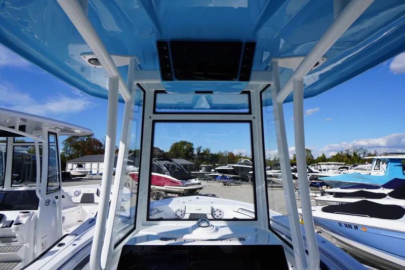 Slide: The Image of 2026 Tidewater 220 LXF boat interior with blue canopy, docked among other boats. - 25