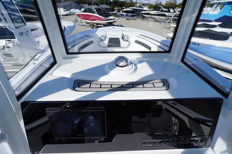 Slide: The Image of 2026 Tidewater 220 LXF boat dashboard with compass and navigation controls. - 30