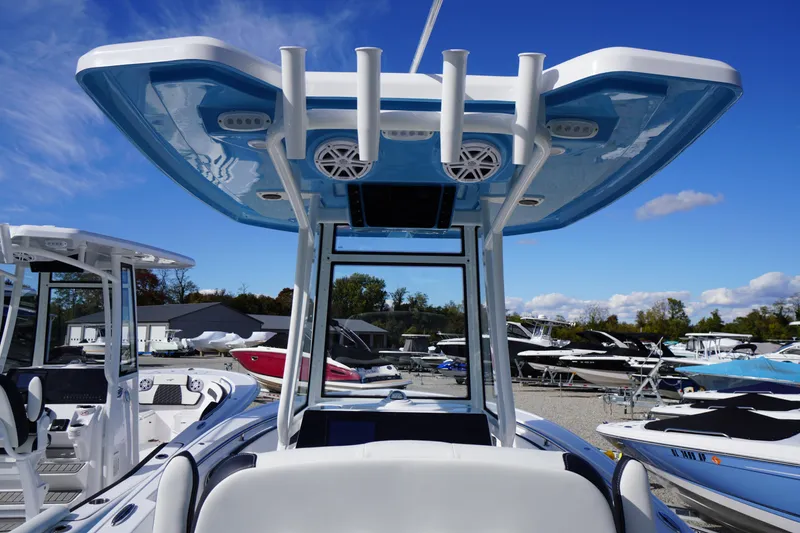Slide: The Image of 2026 Tidewater 220 LXF boat with blue T-top, docked under clear sky. - 35