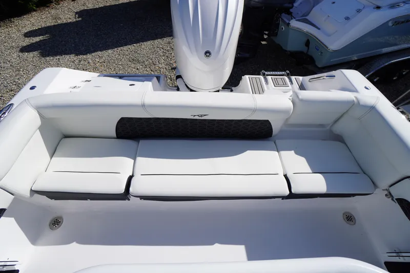 Slide: The Image of 2026 Tidewater 220 LXF boat interior with white cushioned seating and motor. - 38