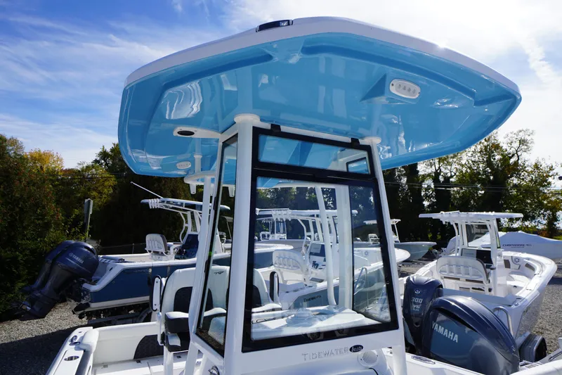 Slide: The Image of 2026 Tidewater 220 LXF boat with blue T-top and Yamaha outboard engines. - 63