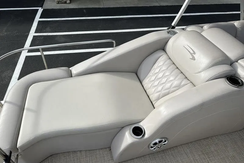 Slide: The Image of 2014 Bennington 2575 RCW boat interior with beige seating and dark wood table. - 11