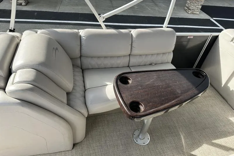 Slide: The Image of 2014 Bennington 2575 RCW boat interior storage compartment with beige and black design. - 14