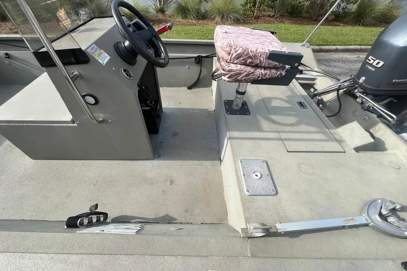 Slide: The Image of 2014 Alumacraft 1756 All Weld MV CC boat interior with steering console and camo seat. - 6