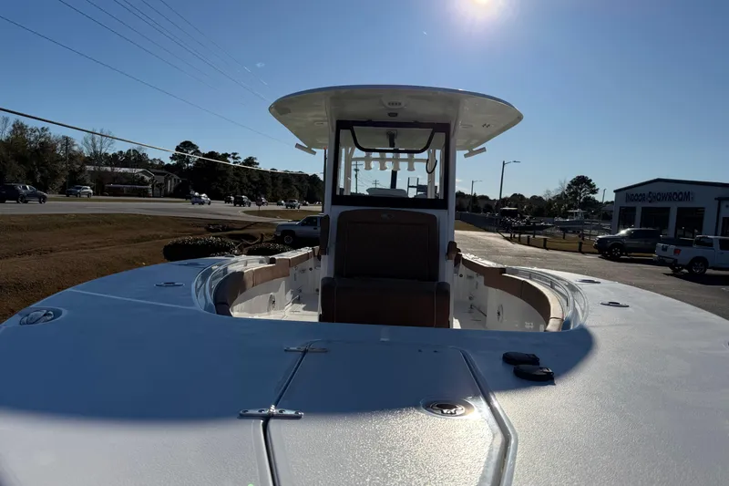 Slide: The Image of 2026 Sea Hunt Ultra 285 Coffin Box boat displayed outdoors under clear sky. - 11
