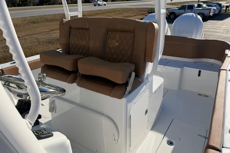 Slide: The Image of 2026 Sea Hunt Ultra 285 Coffin Box boat interior with brown cushioned seating. - 13
