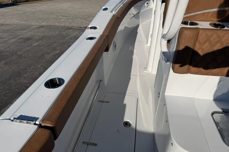 Slide: The Image of 2026 Sea Hunt Ultra 285 Coffin Box boat interior with brown seating and cup holders. - 18