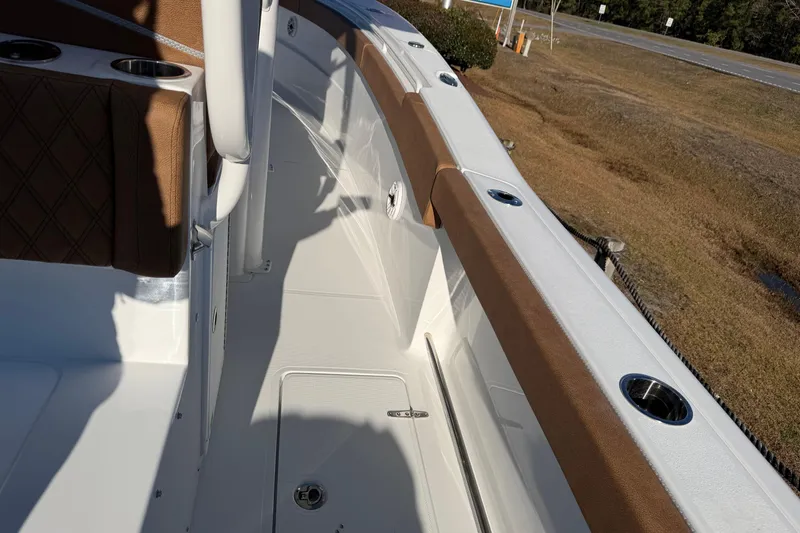 Slide: The Image of 2026 Sea Hunt Ultra 285 Coffin Box boat interior with brown seating and cup holders. - 19