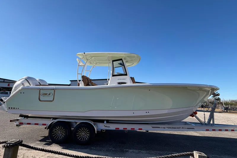 Slide: The Image of 2026 Sea Hunt Ultra 285 Coffin Box boat on trailer under clear blue sky. - 6