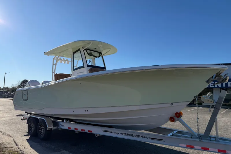 Slide: The Image of 2026 Sea Hunt Ultra 285 Coffin Box boat on trailer under clear sky. - 7