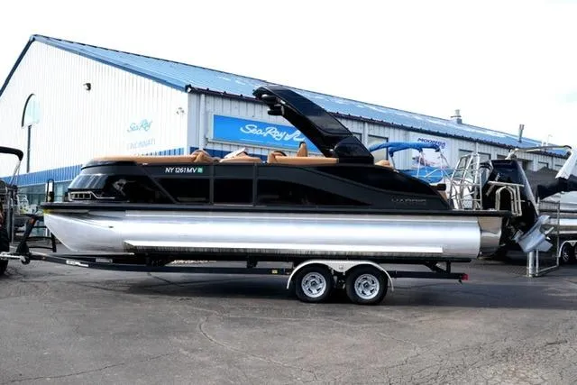 The Image of 2025 Harris Grand Mariner SL 230 pontoon boat on trailer outside dealership. - 0