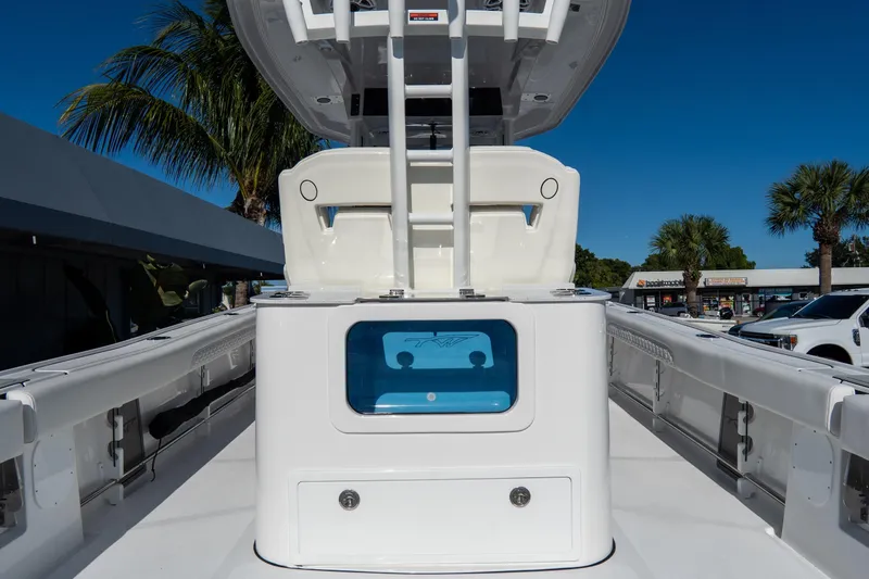 Slide: The Image of 2026 Tidewater 3100 Carolina Bay boat interior with seating and storage, under clear blue sky. - 22