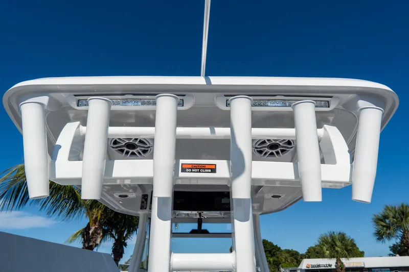 Slide: The Image of Tidewater 3100 Carolina Bay 2026 boat with rod holders and speakers, under clear blue sky. - 23