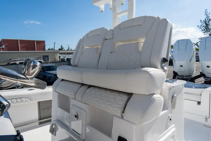 Slide: The Image of 2026 Tidewater 3100 Carolina Bay boat with luxurious white seating and dual outboard engines. - 26