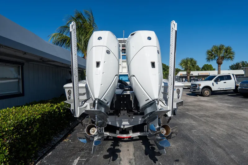 Slide: The Image of 2026 Tidewater 3100 Carolina Bay boat with dual outboard engines, parked outdoors. - 4