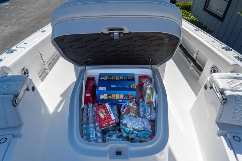 Slide: The Image of Storage compartment on 2026 Tidewater 3100 Carolina Bay boat filled with snacks and drinks. - 46