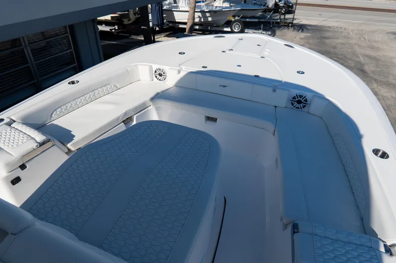 Slide: The Image of 2026 Tidewater 3100 Carolina Bay boat interior with cushioned seating and speakers. - 54