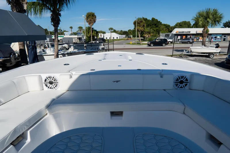 Slide: The Image of 2026 Tidewater 3100 Carolina Bay boat interior with white seating and speakers, docked near palm trees. - 56