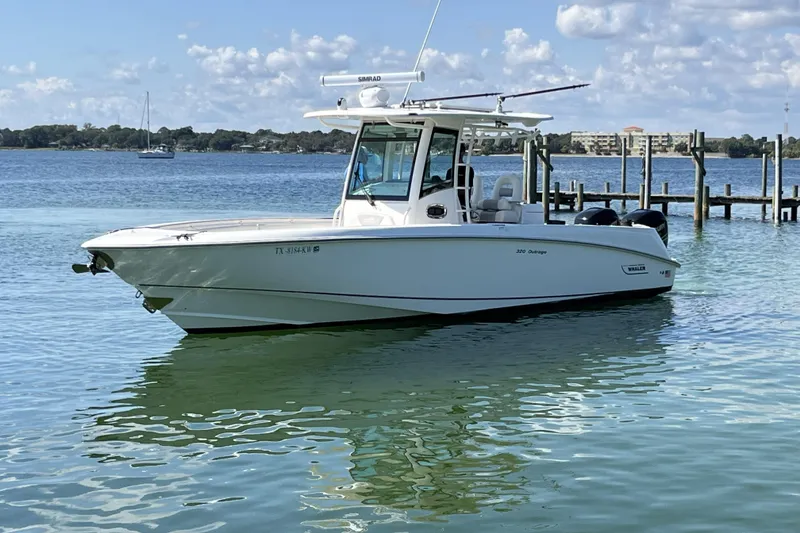 Slide: The Image of 2012 Boston Whaler 320 Outrage boat on calm water, clear sky background. - 0