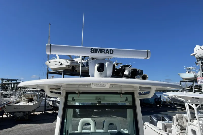 Slide: The Image of 2012 Boston Whaler 320 Outrage with Simrad radar, docked at marina under clear blue sky. - 10