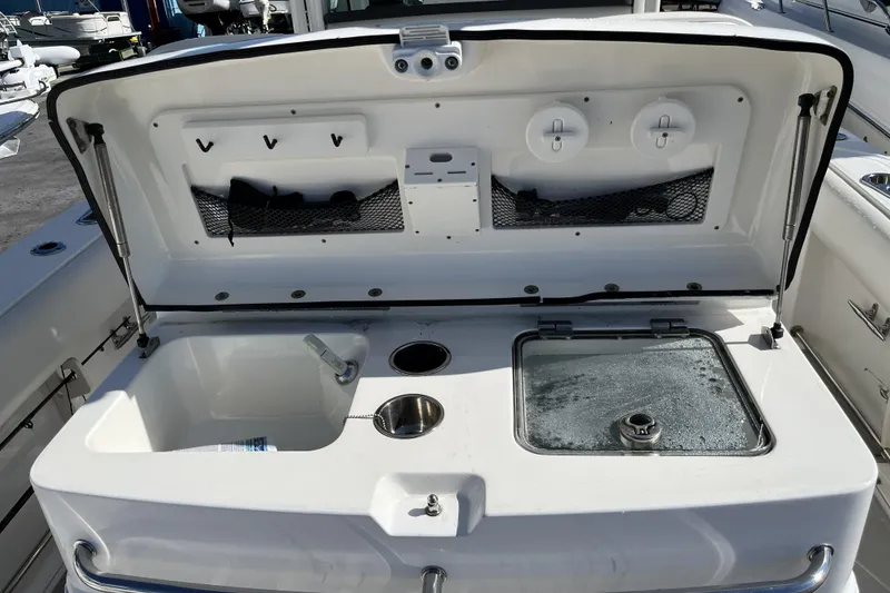 Slide: The Image of 2012 Boston Whaler 320 Outrage boat interior with storage compartments and sink. - 13
