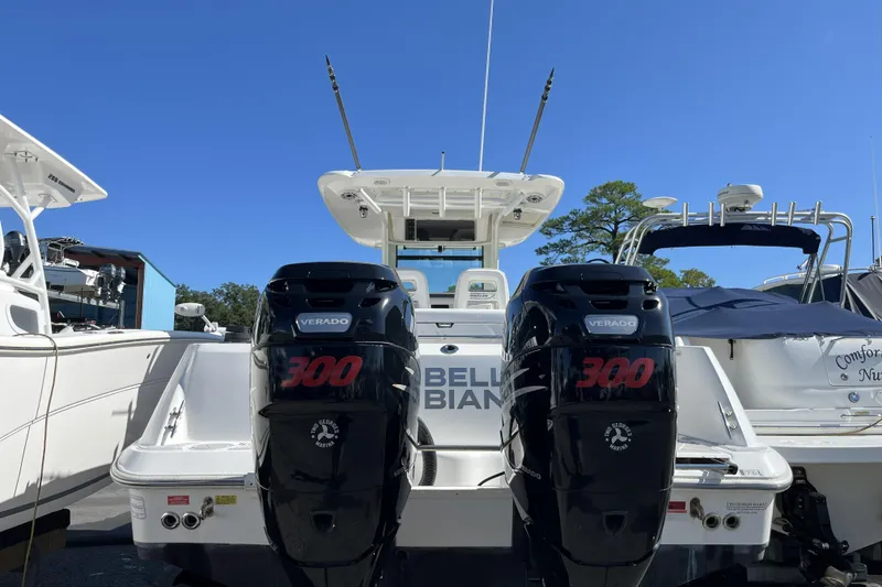 Slide: The Image of 2012 Boston Whaler 320 Outrage with twin 300 Verado engines, docked under clear blue sky. - 4