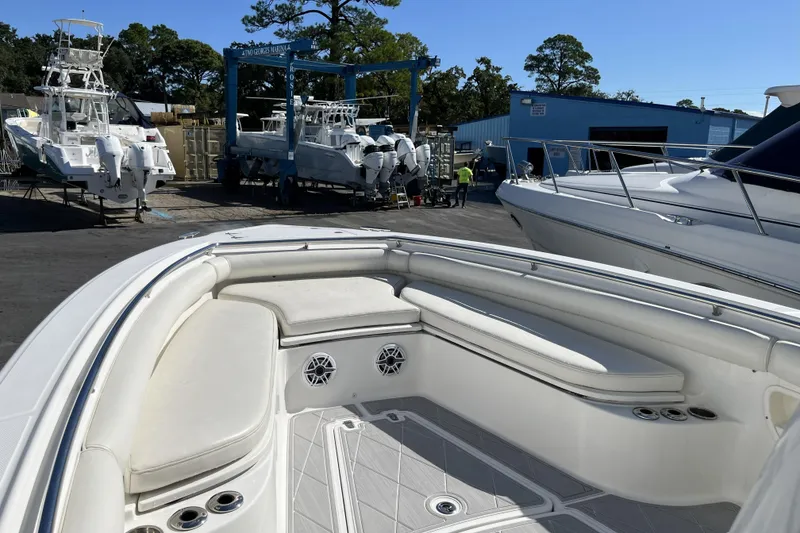 Slide: The Image of 2012 Boston Whaler 320 Outrage boat at marina, showcasing spacious seating and sleek design. - 8